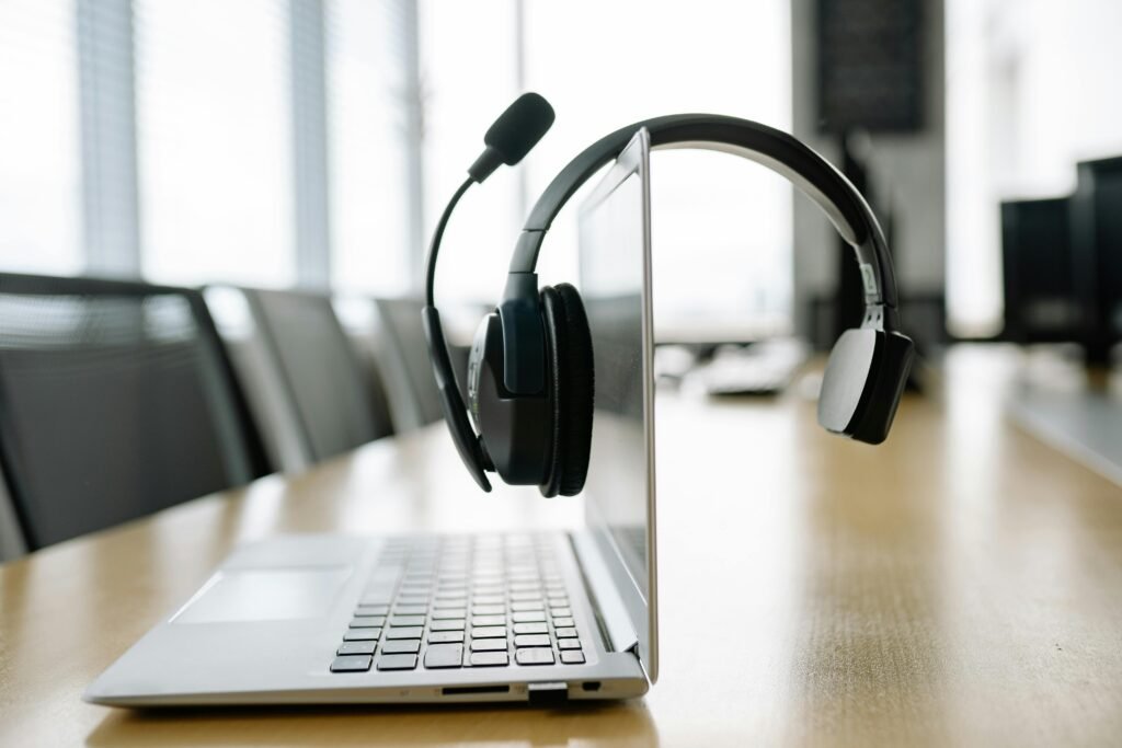 pexels-photo-8866726-8866726-1 Sleek laptop with a wireless headset in a bright, modern office setting.